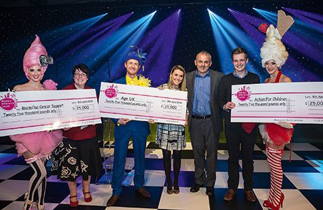 Neil Turton, chief executive of Nisa, third right, and artists at the organisation’s Stoneleigh Park dinner present charity cheques to Age UK, Macmillan Cancer Support and Action For Children.
