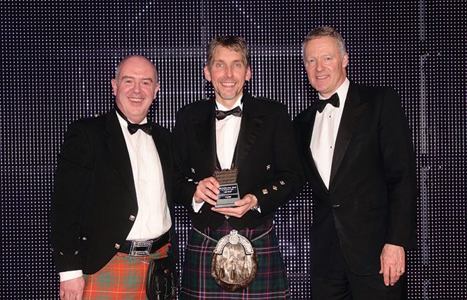 Mark Bruce, sales and marketing director of Border Biscuits, left, and awards event host Rory Bremner, right, present the Scottish Grocer Entrepreneur of the Award 2015 to Colin Smith of Nisa Local Pinkie Farm convenience store.