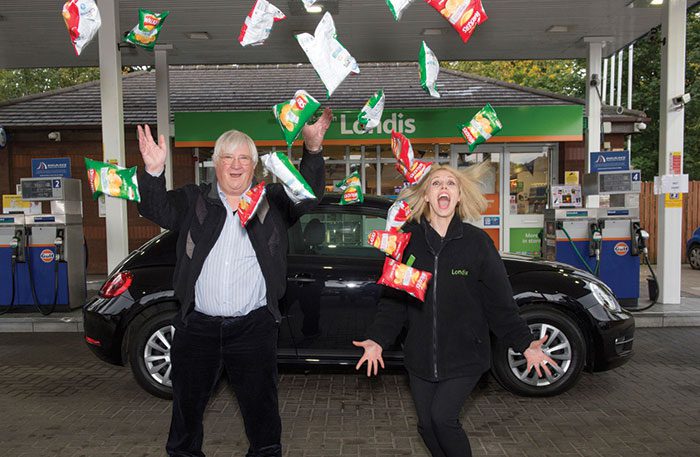 Competition winner Lennart Palleson celebrates his win with a Londis staff member at the Liberton Garage in Edinburgh.