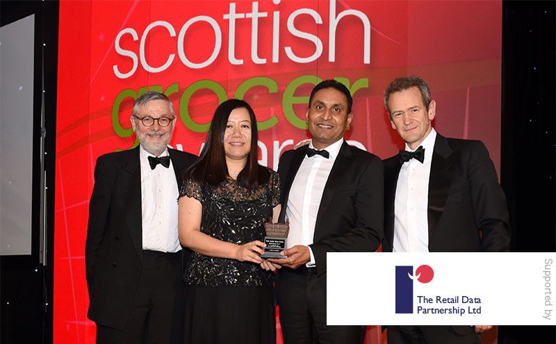 Stephen Burnett, managing director of The Retail Data Partnership and Alexander Armstrong present the Merchandising Award to Mahmood Saleem and Junfang Yun, Ardeer Services.